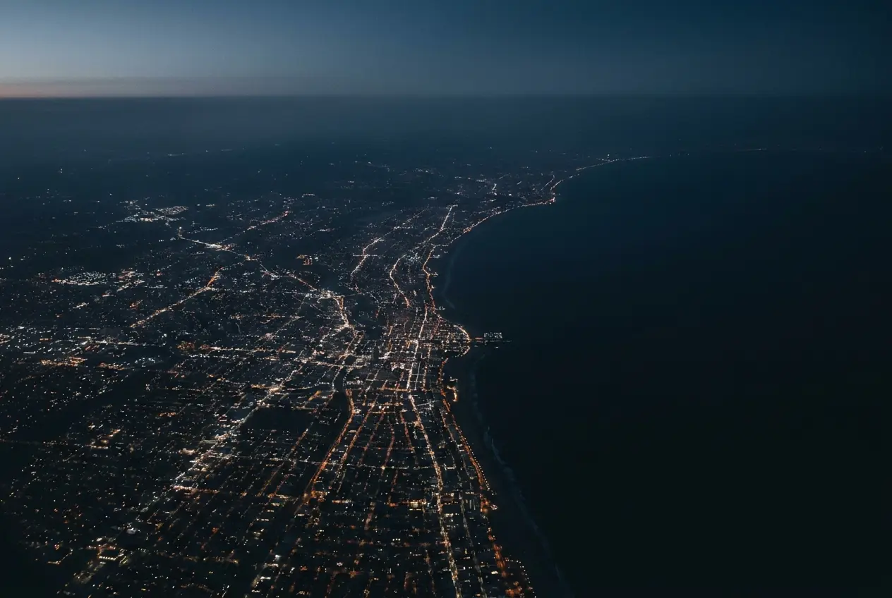 Aerial map view of a dark coastline with city lights